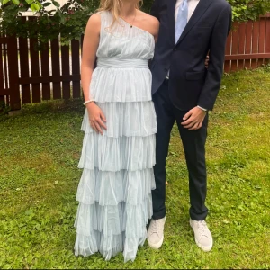 Ljusblå balklänning - Säljer nu min balklänning som jag använde förra året som nu är väldigt eftertraktad. En ljusblå volang klänning med one shoulder modell🩵Storleken är 40 men är lite uppsydd på längden med son går att sprätta upp om man vill ha den längre. Lite insydd runt bröstet vilket självklart också går att sprätta upp. Jag är 173 cm och det sitter perfekt på mig som den är nu!🩵DMa om du har fler frågor!!
