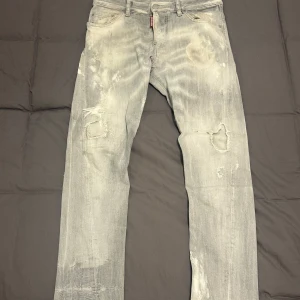 Grå jeans från Dsquared2 - Snygga grå jeans från Dsquared2 med slitna detaljer och en modern look. De har en klassisk femficksdesign och en knappgylf. Perfekta för en avslappnad stil med en touch av edge.
