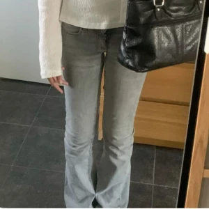 Grå bootcut jeans - Snygga grå bootcut jeans med en klassisk femficksdesign. De har en knapp och dragkedja framtill och är perfekta för en avslappnad stil. Passar bra till både sneakers och klackar. Är sydda låg midja t men kan sprettas upp. 