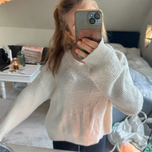 Vit stickad tröja från KappAhl - Mysig vit stickad tröja från KappAhl i storlek 158/164. Tröjan har en rund halsringning och långa ärmar. Något nopprig.