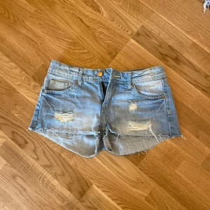 Blå jeansshorts med slitningar - Ljusblå shorts från h&m i storlek 34, säljer för att dom tyvärr blivit för små🫶🏼