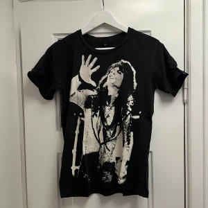 T-shirt med tryck  - Svart T-shirt med vitt tryck föreställande Steven Tyler, sångaren i Aerosmith. 