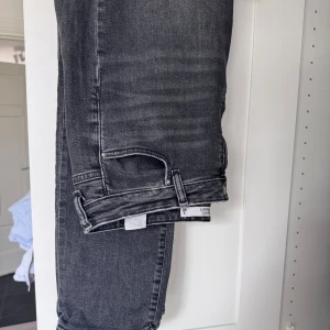 Grå mom fit jeans - Snygga grå mom fit jeans med rak passform. Perfekta för en avslappnad stil. De har en klassisk design med fem fickor och en bekväm midja.