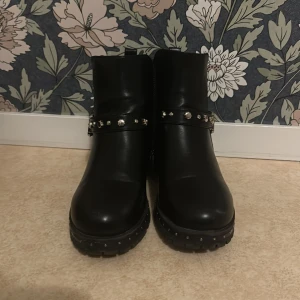 Stylish svarta skor🫶🏾 - Snygga svarta boots från Zara med dekorativa nitar🫶🏾 och ett stiligt spänne runt ankeln. Skorna har en robust sula och en liten klack för extra höjd.😍 Perfekta för att ge din outfit en Stylish touch.