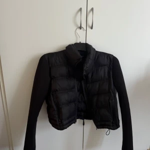 Svart pufferjacka från Zara - Säljer en svart pufferjacka från Zara. Jackan har en croppad design med långa ärmar och dragkedja framtill. Perfekt för en stilren look. och passar även perfekt nu till våren!