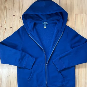 Blå hoodie från Ralph Lauren - Säljer en snygg blå zip hoodie från Ralph Lauren. Galet nice asså har växt ur den dock. 