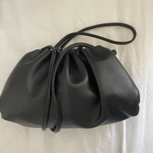 Svart dumpling väska - Snygg svart dumpling väska från BOW19. Helt ny och aldrig använd med etikett på. Säljer för att det inte var öppet köp, nypris: 599:-