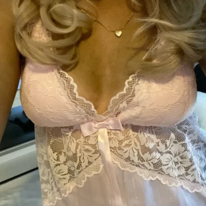 Rosa spetslinne med rosett - Säljer ett romantiskt rosa linne med spetsdetaljer och en söt rosett framtill. Linnet har en vacker v-ringning och är perfekt för speciella tillfällen 💞💕💘