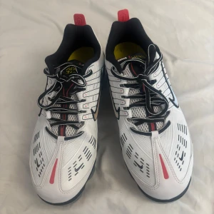 Nike Vapormax vita sneakers - Nike Vapormax sneakers i vitt med svarta och röda detaljer. Snygg futuristisk design med synlig bubbelsula, svarta snören och meshpaneler för extra ventilation. Silverfärgad swoosh på sidan och röd dragflik bak. Perfekta för dig som gillar streetstyle och sportig look.   HELT NYA