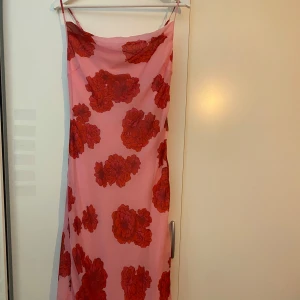 Blommig Klänning - Säljer denna blommiga klänningen, den är helt ny och har endast testats (ingen prislapp kvar dock). Klänningen har spagettistraps, går att stänga vid sidan med en dragkedja och når ner till fötterna. Nypris 500 kr