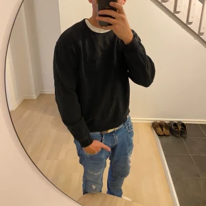 Svart sweatshirt Tiger of Sweden M - Svart sweatshirt från Tiger of Sweden med broderad logga på bröstet. Klassisk rund halsringning och långa ärmar. Tröjan är i mjuk bomull och har en relaxed passform som funkar till jeans eller joggers.