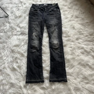 Svarta bootcut jeans från LTB W27 L30 - Snygga svarta jeans från LTB med bootcut-modell och låg midja. Jeansen har slitna detaljer på knäna och råa kanter nertill för en cool vibe.                     Pris kan diskuteras ❤️❤️❤️Tillverkade i klassiskt jeanstyg och perfekta för dig som gillar en avslappnad men trendig look.