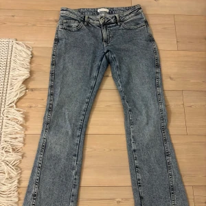 Blå bootcut lågmidjade jeans från Gina tricot  - Snygga blå lågmidajde bootcut jeans från Perfect Jeans med coola broderade bakfickor i kontrastfärg. Klassisk femficksmodell med bälteshällor och dragkedja. Jeansen har en lätt tvättad look och är perfekta 