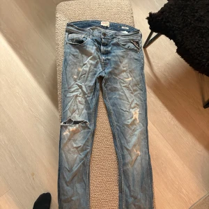 Replay Grover jeans i ljusblå denim - Säljer ett par Replay Grover jeans i ljusblå denim med slitningar och hål för en riktigt avslappnad vibe. Klassisk femficksmodell, raka ben och snygga detaljer på bakfickorna. Perfekta för dig som gillar en streetig look.