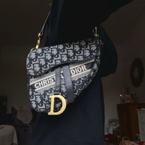 Supersnygg Axelremsväska Crossbody Axelväska  - Säljer en superfin väska som är välanvänd, har normalt tecken på slitage såsom att de guldiga spännen som sitter på sidorna är lite repiga & tappat färg, axelremsbandet har någon reva i sig men mer att jag bara ville nämna att den har lite skavanker men oavsett är de en mega läcker väska som passar jämt!