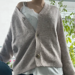 Beige stickad kofta med knappar - Mysig beige stickad kofta med stora knappar framtill och v-ringad hals. Koftan lös passform och passar perfekt till vinter eller höst 💞