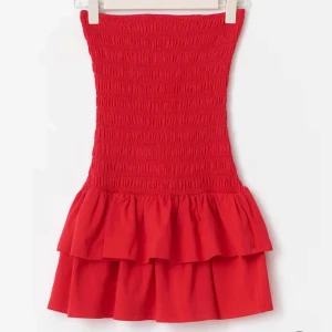 Röd tubklänning med volang från Gina Tricot - Säljer en snygg röd tubklänning från Gina Tricot i storlek S men passar XS också. Klänningen har smockad överdel och två lager volang nertill. Modellen är kort och ärmlös, perfekt för varma dagar. Färgen är väldigt fin och får en att se brunare ut