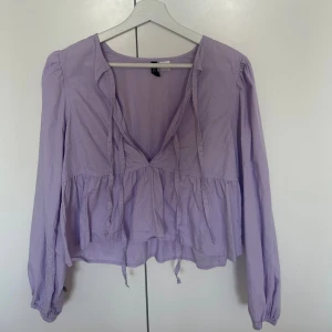 Ljuslila blus  - Supersöt ljuslila blus från H&M med v-ringning och knytband framtill. 