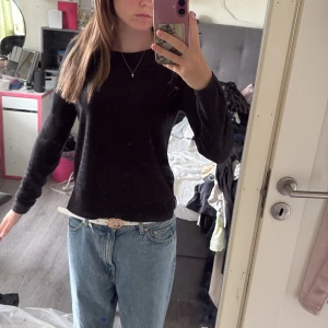 Svart stickad tröja Jacqueline de Yong - Svart stickad tröja från Jacqueline de Yong i storlek S. Tröjan har diskreta horisontella ränder i strukturen, rund halsringning och långa ärmar. Perfekt till jeans eller kjol för en chill och stilren look.