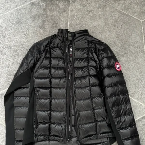 Canada Goose Jacka - Tja, Säljer en äkta & snygg, varm svart dunjacka från Canada Goose. Jackan är intill inte använd, som ny och fräsch. Perfekt för kalla dagar och håller dig varm och stilren. Passar perfekt till vardagen. Kan såklart sänka priset vid snabb affär. Jackan passar även bra i M. Pris kan diskuteras