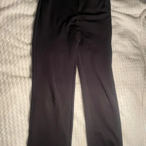 Kostymbyxor  - Svarta byxor från Vero Moda i modellen slim straight. Klassisk look med raka ben, diskret knäppning och bälteshällor. Snygga till både sneakers och boots. Materialet är mjukt och följsamt, perfekt för en clean och stilren outfit. De är lite noppriga därav priset, priset kan diskuteras 💕💕