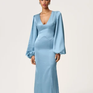 Helt ny Adoore klänning storlek 38 blå - Supersnygg ljusblå långklänning med v-ringning och puffiga långärmar. Klänningen har en figurnära passform och är gjord i glansigt satinmaterial som ger en lyxig känsla. Perfekt för dig som vill sticka ut med elegans och stil. Helt ny med alla tags kvar. Storlek 38 (obs liten i storlek) blå, nypris: 1695kr