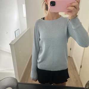 Ljusblå tröja från Stockh LM strl S - Superskön ljusblå tröja från Stockh LM i storlek S. Tröjan har ett vågigt mönster över hela ytan, rund halsringning och långa ärmar. Perfekt för dig som gillar enkel men snygg stil och vill ha något som funkar till jeans eller kjol. Super fin tröja!