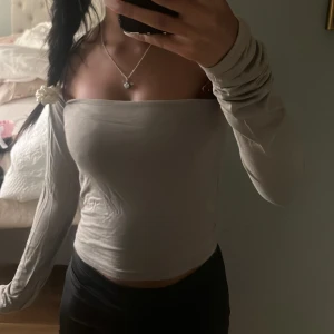 Beige/grön  långärmad topp - Trendig beige  topp med långa ärmar och tight passform. Toppens minimalistiska design gör den lätt att matcha med olika outfits. Perfekt för dig som gillar stilrena och enkla plagg.