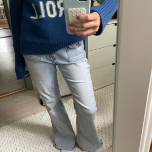 Ljusblå bootcut jeans med låg midja - Säljer ett par ljusblå jeans med bootcut och låg midja. Jeansen har stora framfickor och klassisk femficksdesign. De är tillverkade i mjukt denim och har en avslappnad, lite retro vibe. Perfekta för dig som gillar en chill och trendig look.