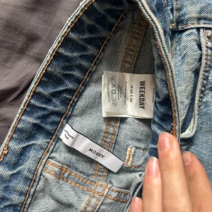 Weekday Arrow ljusblå jeans W25 L30 - Säljer ett par ljusblå Arrow jeans från Weekday med klassisk femficksdesign och raka ben. Jeansen har normal passform och är tillverkade i bomull med snygga kontrastsömmar. Perfekt för dig som gillar en clean och avslappnad stil.