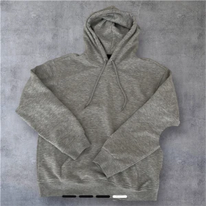 Grå hoodie från H&M  - Säljer en stilren grå hoodie från H&M i loose fit. Tröjan har huva med snörning, magficka och långa ärmar med ribbade muddar. Perfekt för chill dagar eller när du vill ha en enkel och clean look. Nästan aldrig använd