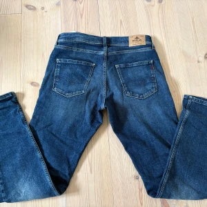 Blå  Replay Wallys Jeans - Snygga blå jeans från Replay, modell Wallys. Klassisk femficksdesign med raka ben och tvär feta detaljer på bakfickorna. Jeansen är i ett mörkare blått denimtyg med kontrastsömmar och Replay-lapp bak i midjan. PRISET KAN DISKUTERAS!! Dom är endast använda två gånger!