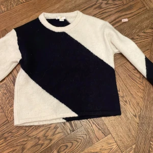 Vit och marinblå stickad tröja Gina Tricot - Säljer en stickad tröja från Gina Tricot med breda diagonala block i vitt och marinblått. Storlek 134/140
