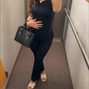 Svarta kostymbyxor med bootcut från Bikbok - Säljer ett par svarta kostymbyxor med bootcut-snitt och hög midja. Byxorna har klassisk passform och är perfekta för en clean och stilren look. Materialet känns mjukt och följsamt, vilket gör dem bekväma hela dagen.