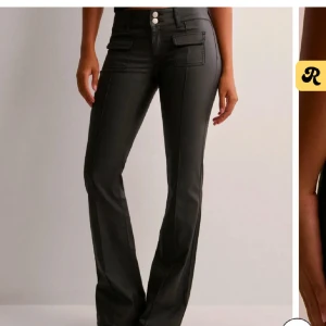 Svarta läderbyxor  - Snygga svarta bootcut byxor med två framfickor med lock och dubbla knappar i midjan. Byxorna har en lätt glansig finish. Använda en gång💕