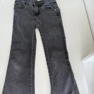 Grå jeans  - Snygga grå jeans med klassisk femficksdesign. Jeansen har coola detaljer som knappar på bakfickorna och bälteshällor. Tillverkade i mjukt denimtyg som ger en avslappnad vibe. Perfekta för dig som gillar en enkel men stilren look. Knapparna på bakfickorna är lite rostiga men förutom det finns inga andra skador. Ord pris 199kr. Pris kan diskuteras.