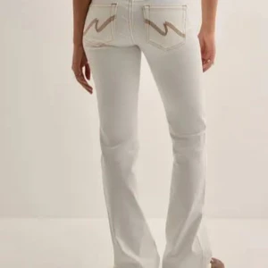Vita bootcut jeans med broderade fickor - Snygga vita bootcut jeans från Nelly! Säljer då de inte används, finns inga defekter! Köpta för 699kr!