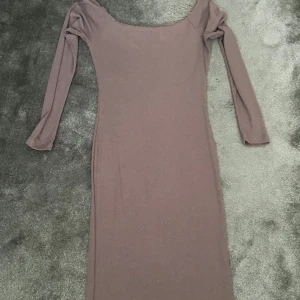 Ljuslila långärmad tight klänning - Säljer en superfin ljuslila klänning med lång ärm och offshoulder-skärning. Klänningen är tight och har en smickrande passform som framhäver figuren. Storlek M men passar S