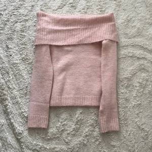 Ljusrosa offshoulder stickad tröja - Superfin ljusrosa stickad tröja från Gina Tricot med bred offshoulder-krage och långa ärmar. Tröjan har ribbade muddar och är perfekt för dig som gillar en söt och trendig look. Mjuk och skön att bära under kyligare dagar.