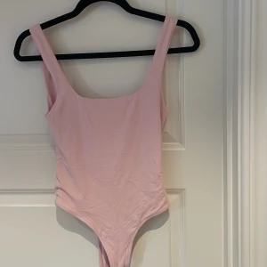 Ljusrosa body från Zara - Supersöt ljusrosa body från Zara med breda axelband och djup rygg.. Tillverkad i mjukt, stretchigt material som sitter skönt på kroppen.