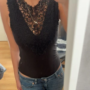 Svart spetsbody - Supersnygg svart body, perfekt på fest! Den är ribbad och sticker ut lite. Tveka inte att fråga om du undrar något! 💌