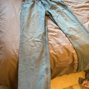 Ljusblå raka jeans - Säljer ett par ljusblå jeans med klassisk rak passform. Jeansen har fem fickor och stängs med dragkedja och knapp. Perfekta för en avslappnad och stilren look.