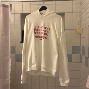 Vit hoodie Maison Margiela med röd print Strl L - Vit hoodie från Maison Margiela med rött tryck Strl L