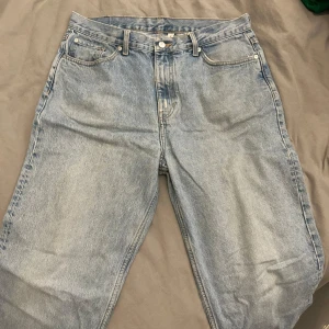 Blå jeans från Weekday - Säljer ett par blå jeans från Weekday i modellen Galaxy Loose Straight. De har en klassisk femficksdesign och är tillverkade i bomull. Perfekta för en avslappnad stil.