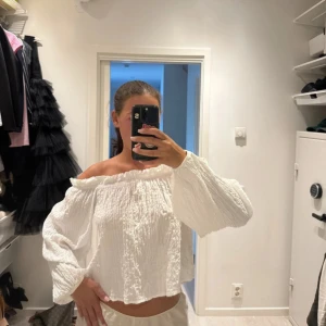 Vit offshoulder blus Gina tricot - Superfin vit blus med offshoulder-modell och vida, långa ärmar. Toppen är stretchig i materialet. Använd en gång🤍 Storlek S men passar också M