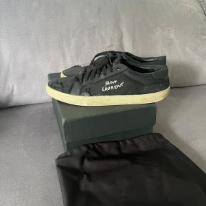 Saint laurent skor - Svarta skor i tyg, storlek 42 passar 43 hyfsat skick, säljer dem då dem inte kommer till någon användning. Box och dustbag medföljer .