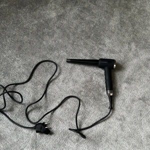 Cera WandBar locktång svart - Säljer en svart Cera WandBar locktång med konformad stav och digitala knappar för temperaturkontroll. Snygg design med silverdetaljer och lång sladd. Perfekt för att skapa snygga lockar och beach waves.