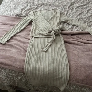 Beige ribbad omlottklänning - Säljer denna jätte söta klänningen, har används 2 gånger