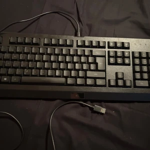 Razer tangentbord - Säljer ett Razer tangentbord med RGB-belysning. Tangentbordet har en stilren svart design och ansluts via USB. Perfekt för gaming med sina responsiva tangenter och anpassningsbara ljuseffekter.