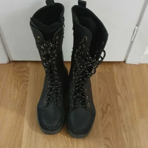 Svarta kängor med snörning - Snygga svarta kängor med hög snörning och dragkedja på sidan. Perfekta för en tuff look och passar bra till både jeans och kjol. Kängorna har en robust design och är idealiska för höst- och vinterväder.